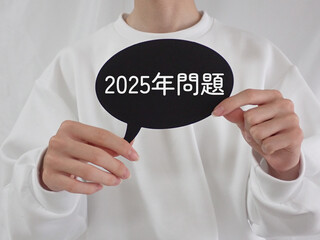 若い男性が持っている吹き出しに2025年問題の文字