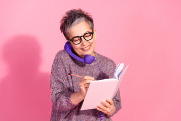 Photo of cheerful pretty lady dressed pullover talking retro phone writing notes empty space isolated pink color background - Powered by Adobe