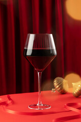 An elegant glass of red wine on a New Year's festive background. Wine store, a winery.