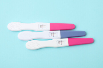 Pregnancy tests on light blue background, above view