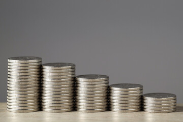 Stacked coins on wooden table against grey background, closeup with space for text. Salary concept