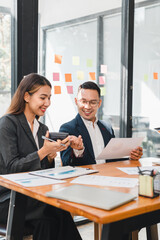business meeting with man and woman discussing documents and ideas. They are engaged and smiling, showcasing teamwork and collaboration
