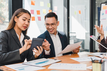 Efficient business meeting with professionals discussing financial data, using calculator, and analyzing reports. Collaboration and teamwork are evident in this productive environment
