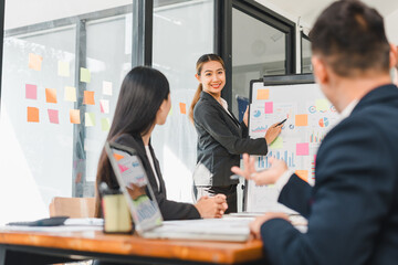 businesswoman presents data to colleagues in modern office setting, showcasing charts and graphs. team engages in discussion, highlighting collaboration and professionalism