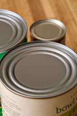 Tops of cans of sauce on a wooden table. 