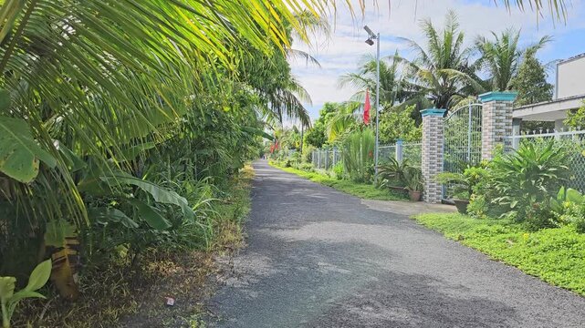 Narrow village street in countryside at Mang Thit district, Vinh Long province, Mekong Delta Vietnam in the morning.