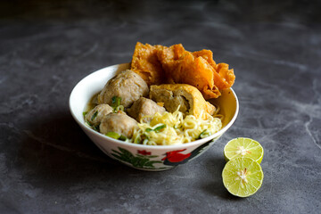 A bowl of Bakso Malang, a popular Indonesian dish featuring meatballs, noodles, and fried tofu served in a savory broth.