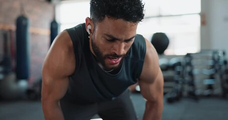 Man, sweat and smart watch in gym for workout, exercise and break with challenge, stopwatch or fitness. Body builder, training and earphones for fatigue, cardio or health app with performance tracker - Powered by Adobe