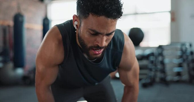 Man, sweat and smart watch in gym for workout, exercise and break with challenge, stopwatch or fitness. Body builder, training and earphones for fatigue, cardio or health app with performance tracker