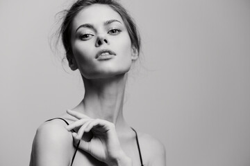 Elegant young woman posing gracefully in a minimalist black and white setting, exhibiting...