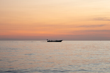 Silhouette of a fishing boat in the sea at sunset.