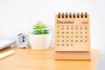 December 2025 desk calendar on worktable.