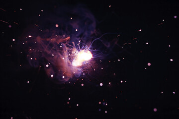 A bright flash of light and a sheaf of sparks in a cloud of smoke. Miniature Universe. Design...