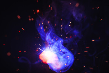 A bright flash of light and a sheaf of sparks in a cloud of smoke. Miniature Universe. Design...