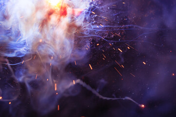 A bright flash of light and a sheaf of sparks in a cloud of smoke. Miniature Universe. Design...