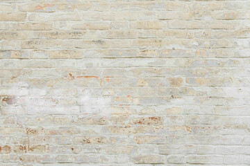 Beige grungy brick wall. Free space for an inscription. Can be used as a background or poster. Fragment of a wall with bumps and shabby plaster.