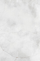 White texture of a concrete wall with natural relief and damage in the form of chips and scratches. Fragment of an old stone surface with a crack. Dark rough surface with a place for an inscription