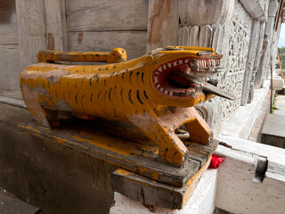 A yellow tiger statue with a red tongue and a black mouth