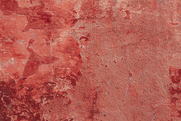 Red texture of a concrete wall with natural relief and damage in the form of chips and scratches. Fragment of an old stone surface with a crack. Dark rough surface with a place for an inscription