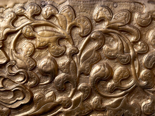 A gold leaf design on a piece of metal