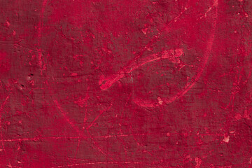 Red texture of a concrete wall with natural relief and damage in the form of chips and scratches. Fragment of an old stone surface with a crack. Dark rough surface with a place for an inscription