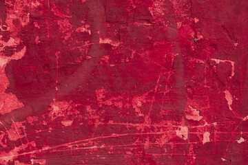 Obraz premium Red texture of a concrete wall with natural relief and damage in the form of chips and scratches. Fragment of an old stone surface with a crack. Dark rough surface with a place for an inscription