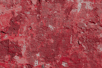 Red texture of a concrete wall with natural relief and damage in the form of chips and scratches....