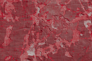 Fototapeta premium Red texture of a concrete wall with natural relief and damage in the form of chips and scratches. Fragment of an old stone surface with a crack. Dark rough surface with a place for an inscription