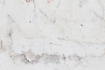 White texture of a concrete wall with natural relief and damage in the form of chips and scratches. Fragment of an old stone surface with a crack. Dark rough surface with a place for text.