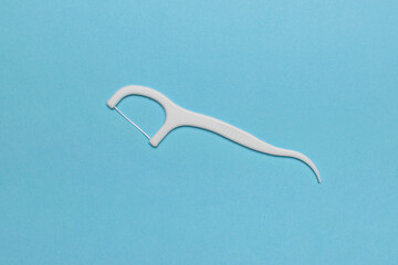 White Dental Floss Pick on Blue Background: Oral Hygiene and Dental Care Stock Image