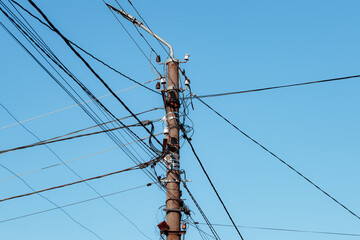 Overhead power lines. Telephone cable. Internet communications. An old post with a bunch of wires....