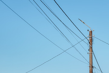 Overhead power lines. Telephone cable. Internet communications. An old post with a bunch of wires....