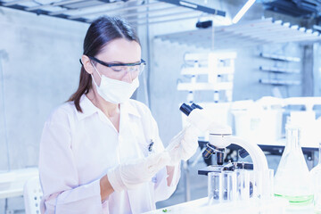 Fototapeta premium Scientist working in high-tech laboratory analyzing specimen under microscope. Ideal for biotechnology, innovation, lab work, and modern science visuals.