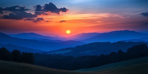 Obraz premium A vibrant sunset illuminates a range of rolling hills, casting long shadows over the landscape.