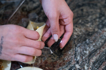 Femenine hands of a woman preparing emapanadas dumplings for baking