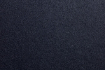 A black background with a few specks of white, textured origami paper backdrop