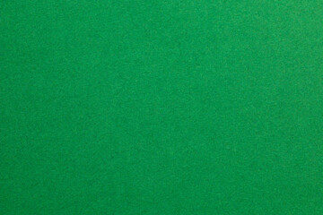 A green background with a few specks of color, textured origami paper backdrop