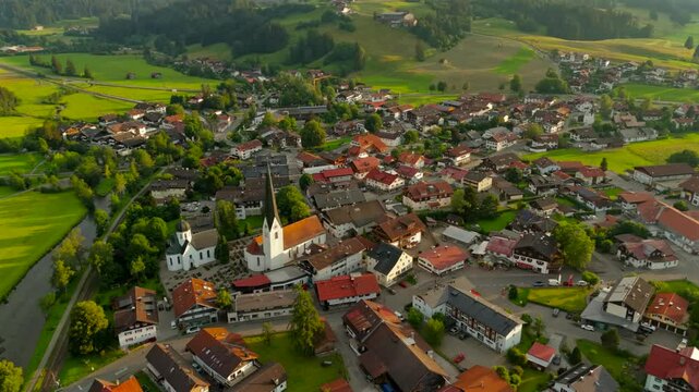 Aerial view of Fischen im Allgau near Oberstdorf at sunset in sunny summer weather in Bavaria, Germany Landkreis Oberallgau. Fischen im Allgaeu Luftaufnahme. Pfarrkirche St. Verena. Frauenkapelle. 