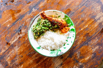 Indonesian dish. Rice with urap-urap (indonesian salad with chili, grated coconut and other spice) and roasted chicken