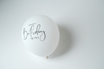 Balloons with Happy Birthday written on them on a white background