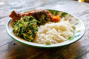 Indonesian dish. Rice with urap-urap (indonesian salad with chili, grated coconut and other spice) and roasted chicken