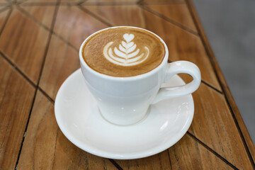 A cup of hot latte coffee on the table for breakfast
