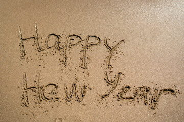 Sending heartfelt Happy New Year wishes beautifully crafted in the sand on the beach