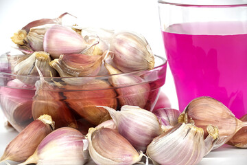 Garlic cloves soak in a potassium permanganate solution, perfect for pest-free growth