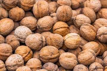 pile of unpeeled walnuts, closeup macro background with selective focus
