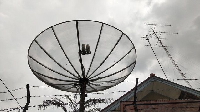 Television mesh parabolic antenna on dark cloudy weather