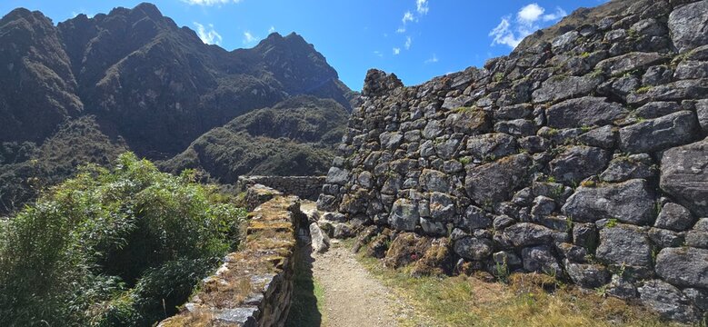 Low stone wall and worn path at Sayacmarca, lost Inca miliary fortress located along the Inca Trail to Machu Picchu. It was never discovered due to its hidden location in the Andes.