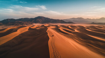 A desert landscape with a person walking in the sand
