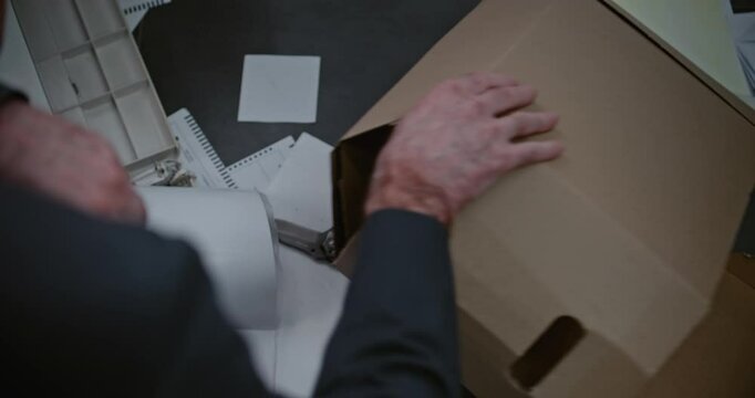 Robbery or murder case in office: Top view on unrecognizable forensic scientist or detective in suit examining evidence at crime scene, finding murder weapon knife. Crime investigation team at work.