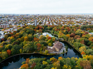 A public park, autumn leaf color change, buildings skyscrapers downtown in the background.